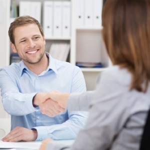 Smiling young man shaking hands with an insurance agent or investment adviser as he sits in a meeting with his wife in her office-762431-edited.jpeg